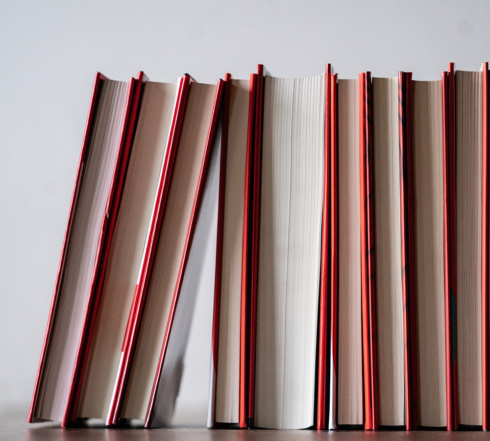 Row of books with red spines on a light gray background